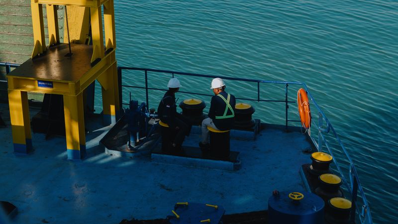 Maritime crew members on vessel deck in safety gear